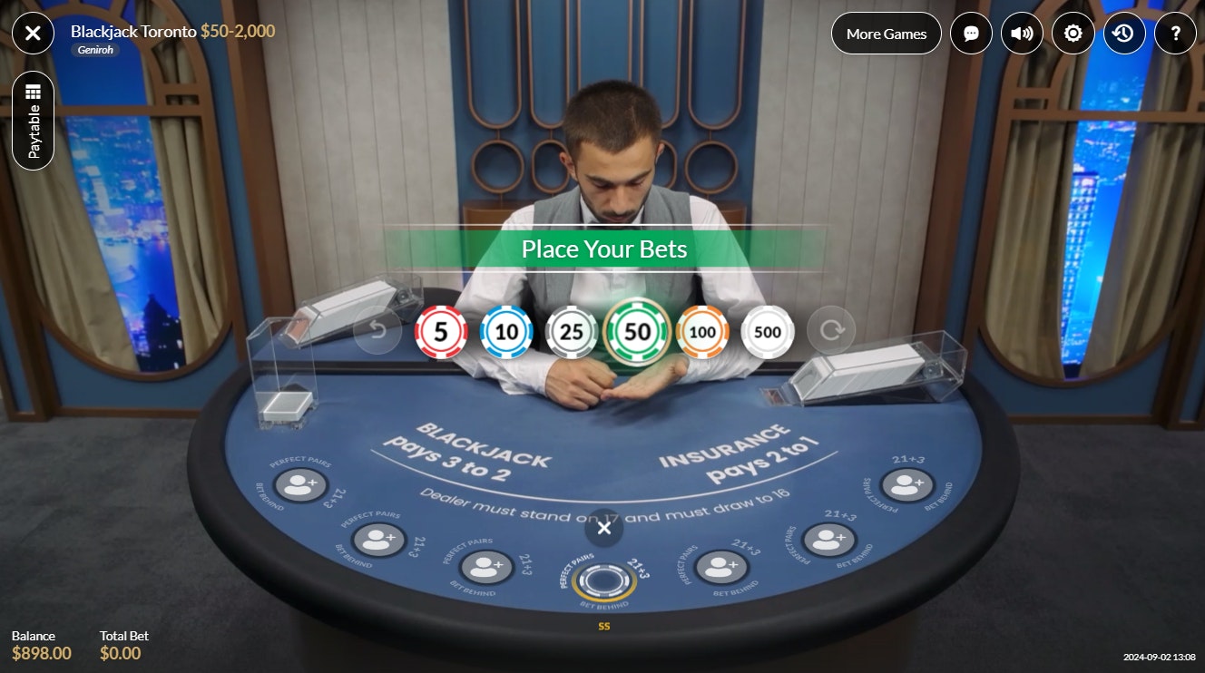 Blackjack Toronto live table open for bets, dealer shuffling behind blue layout. Blackjack Toronto live table open for bets, dealer shuffling behind blue layout.